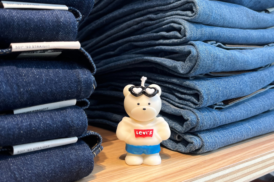 polar bear candle with levis logo next to stacks of folded jeans